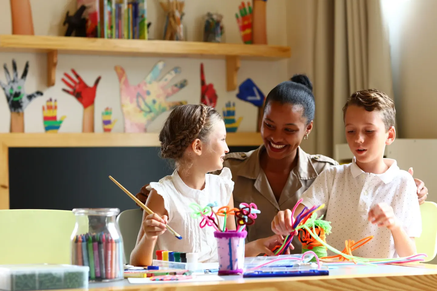 Children make crafts with a staff member at Bahia Principe Explore Legend.