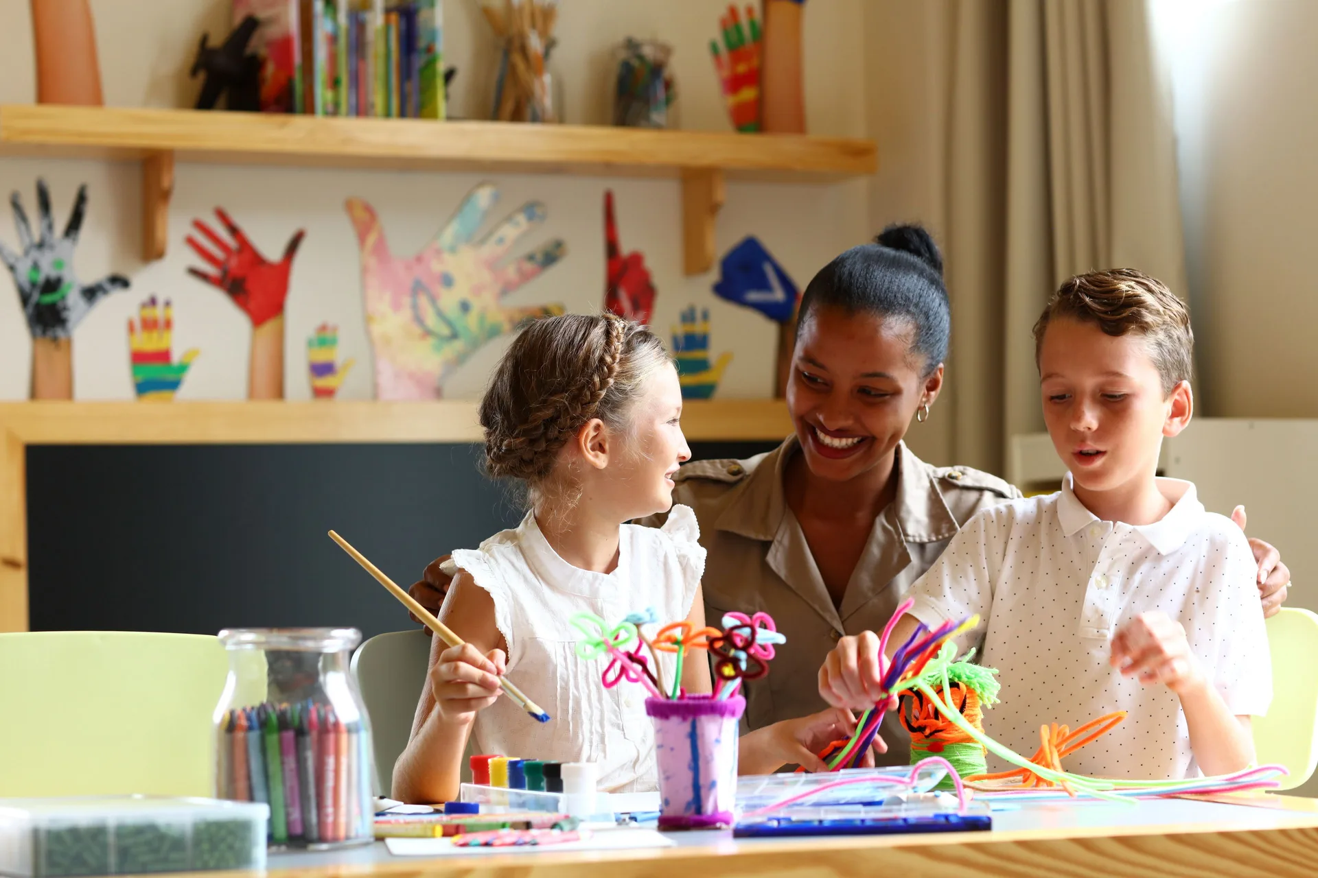 Children make crafts with a staff member at Bahia Principe Explore Legend.
