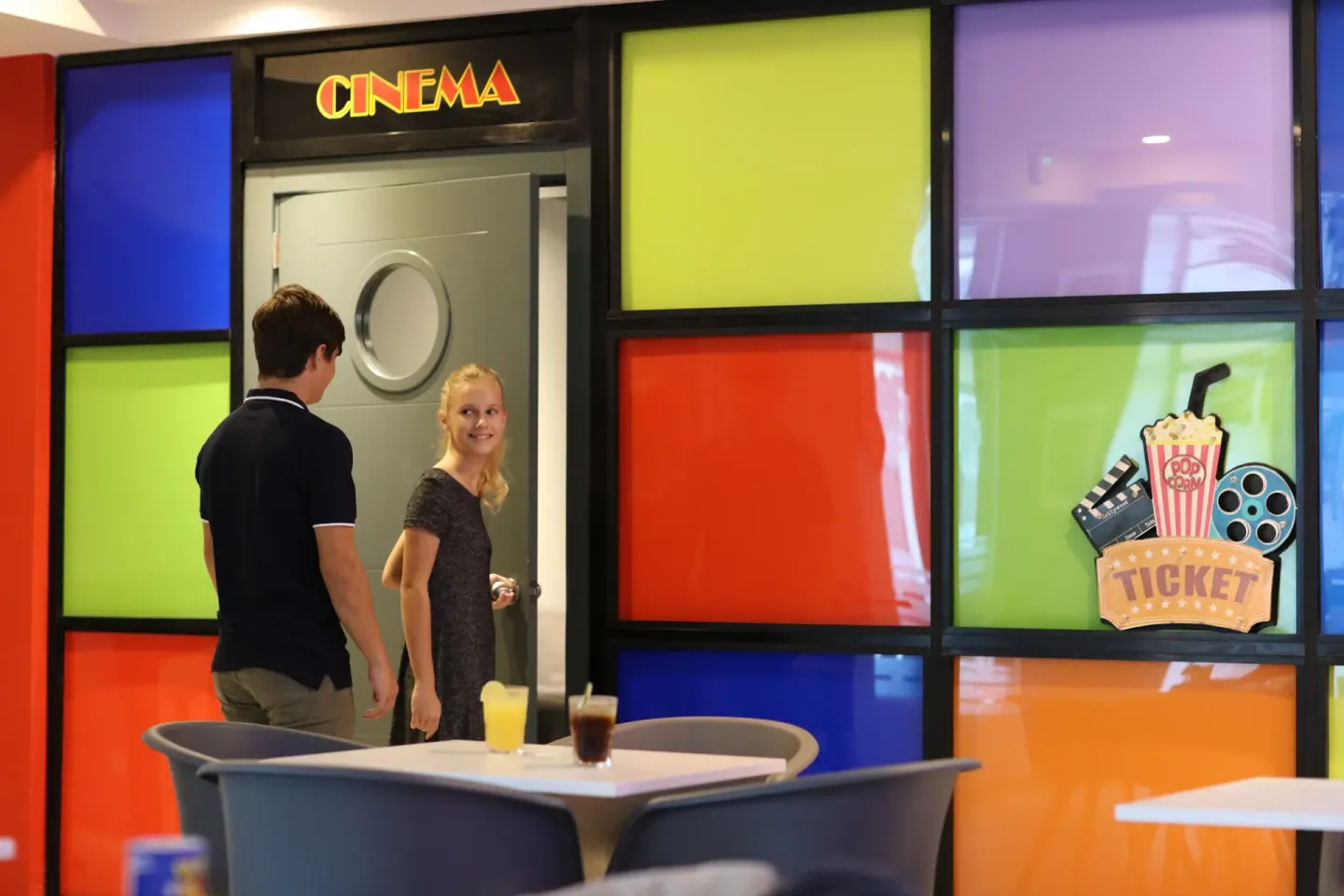 Guests enter a cinema room with colorful glass panels at Bahia Principe Explore Legend.
