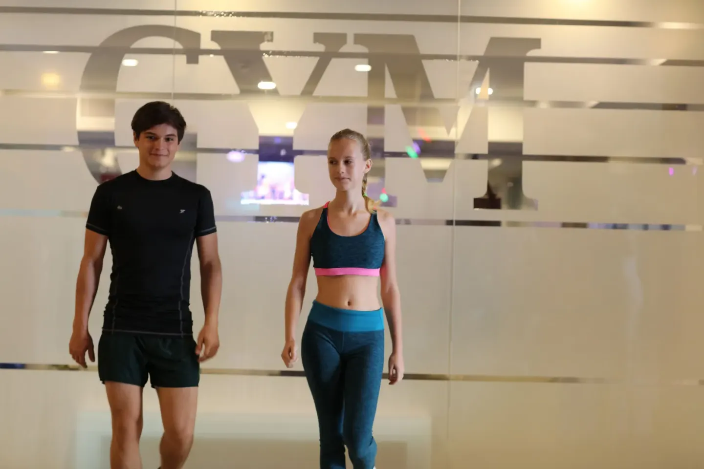 Two guests in athletic wear walk through the gym at Bahia Principe Explore Legend.