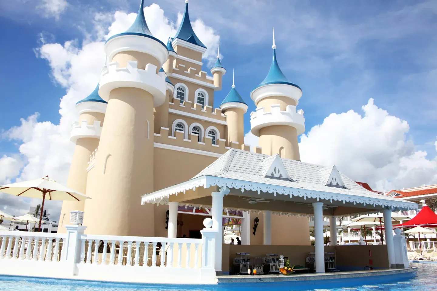 Poolside castle-themed building with blue turrets at Bahia Principe Explore Legend.