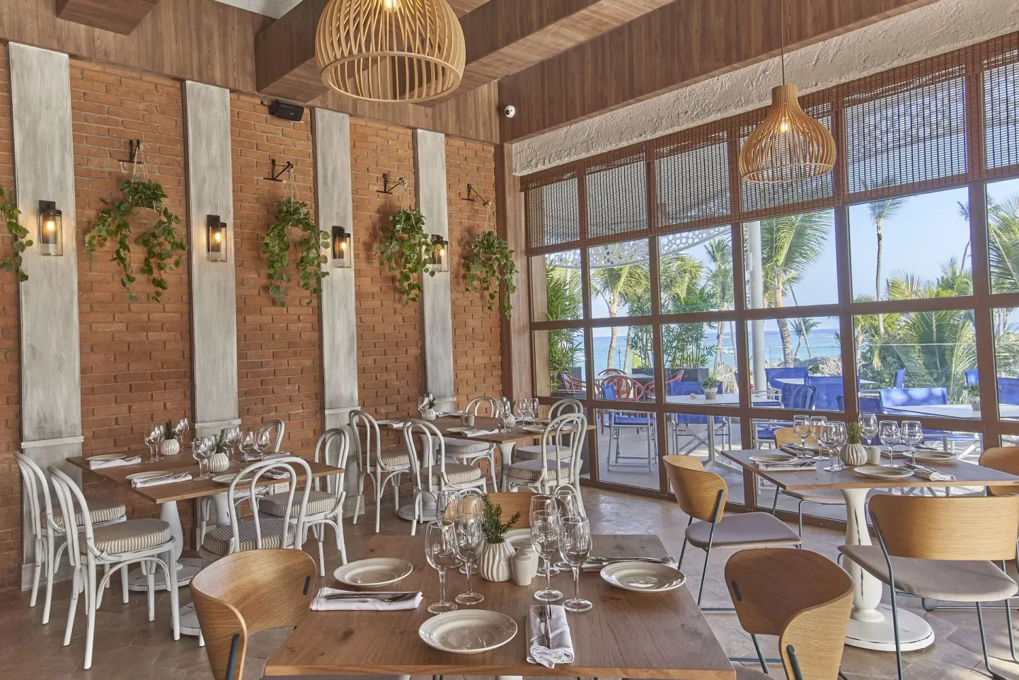 Restaurant dining room with brick walls and ocean views at Bahia Principe Explore Legend.