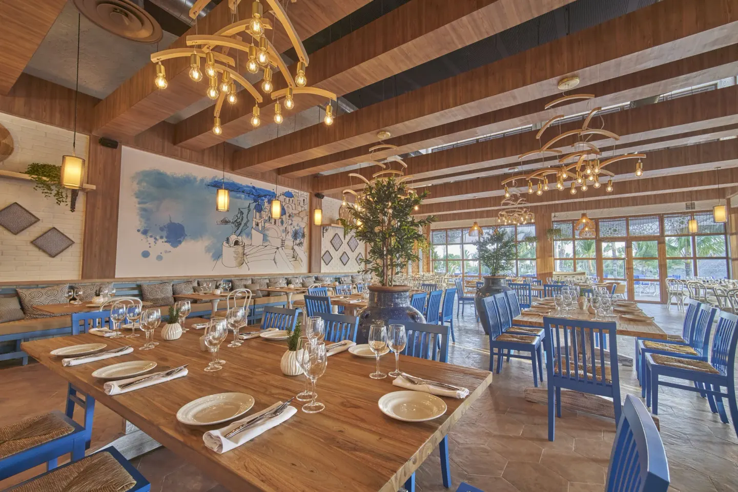 Restaurant dining room with blue chairs and mural wall at Bahia Principe Explore Legend.
