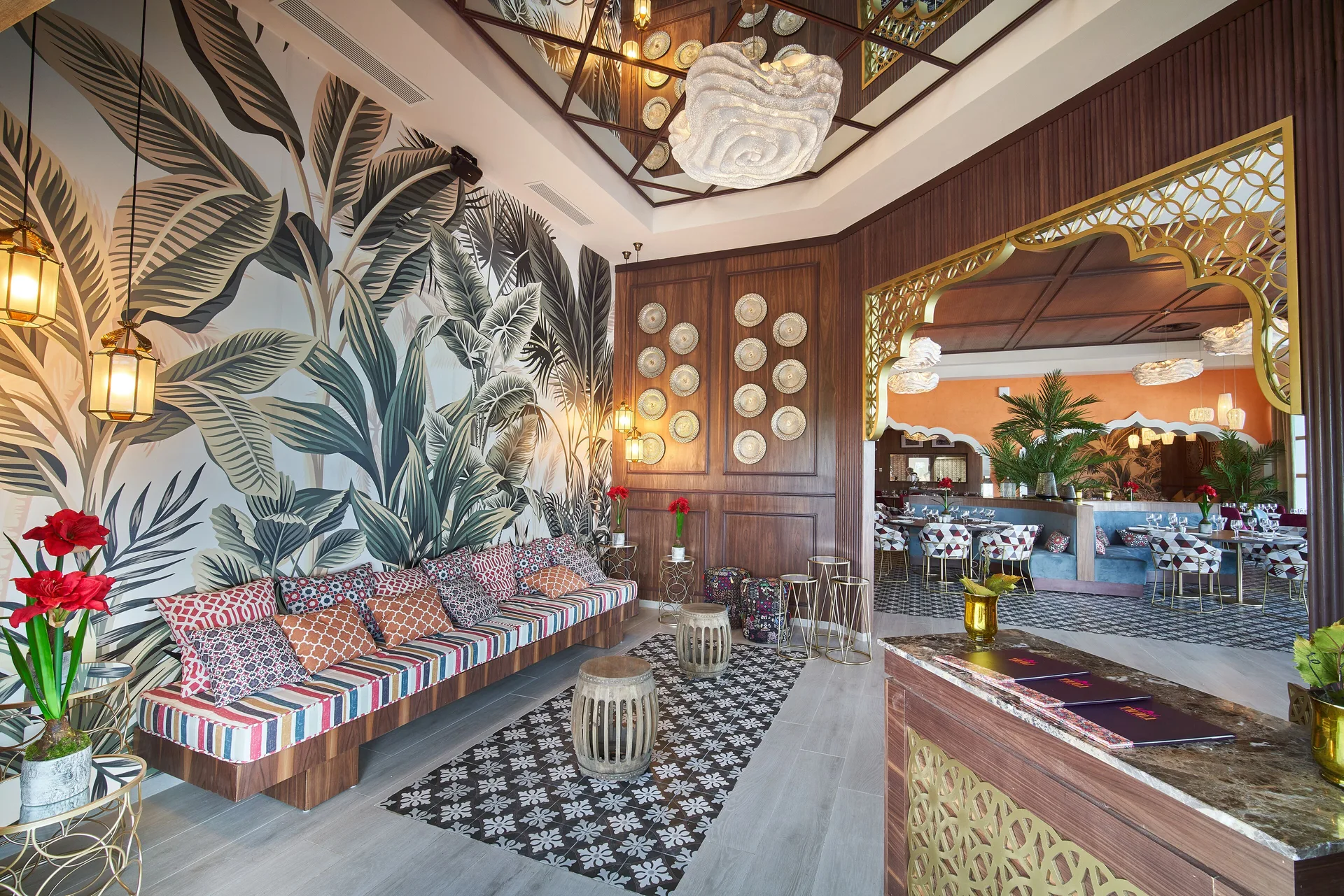 Restaurant entry lounge with leaf mural and patterned bench at Bahia Principe Explore Legend.