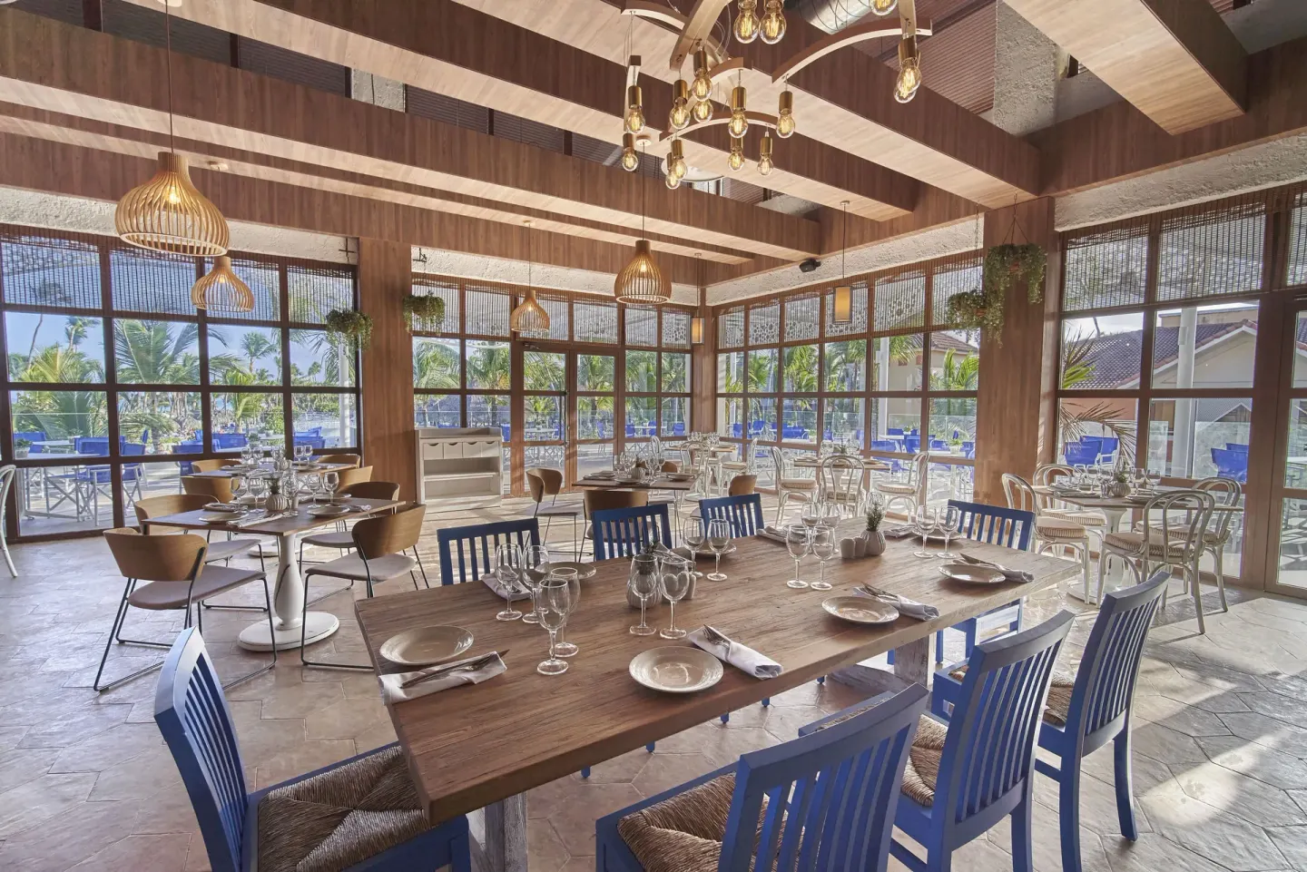 Bright dining room with set tables and garden views at Bahia Principe Explore Legend.