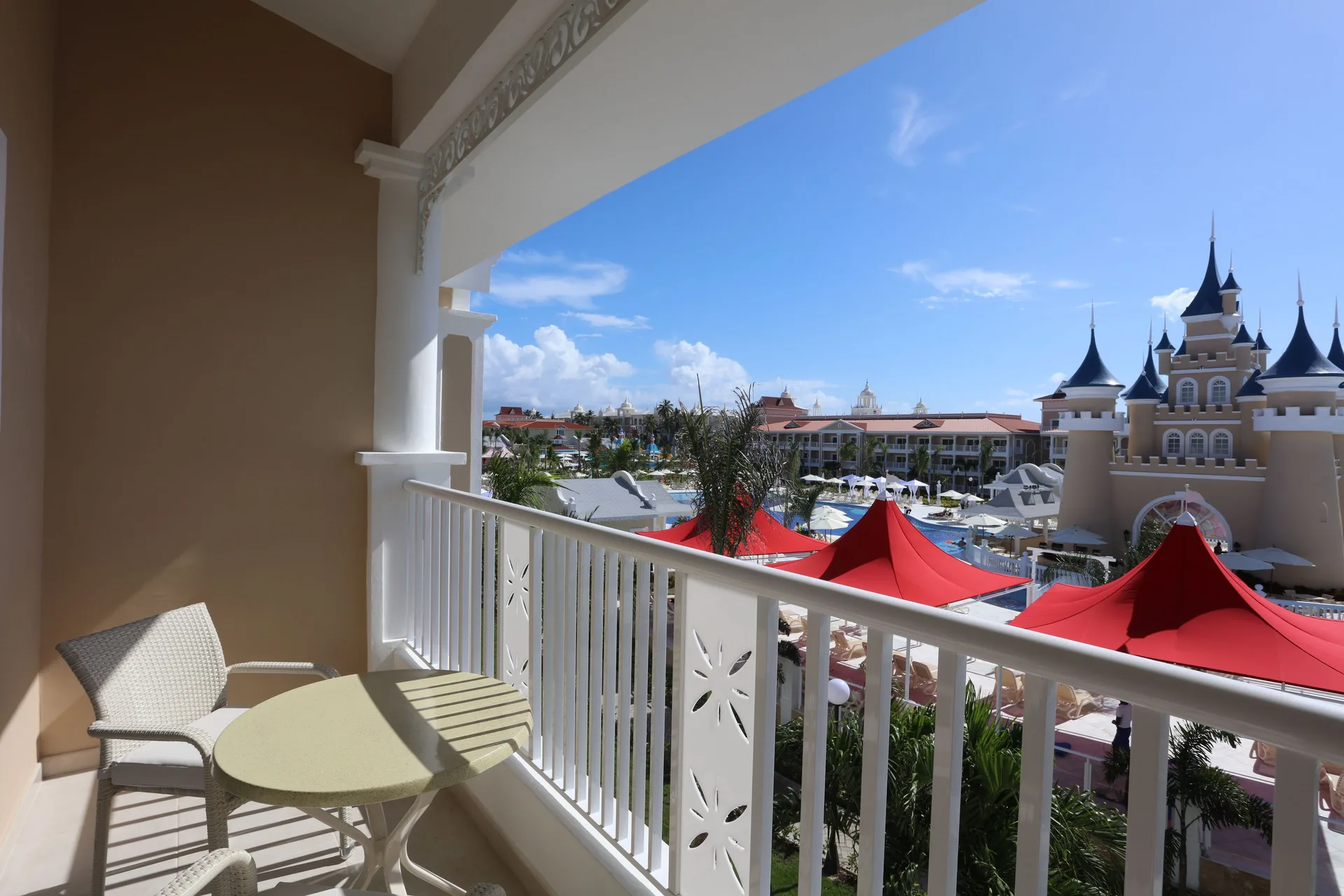 Junior Suite Deluxe Castle View balcony at Bahia Principe Explore Legend with seating and castle-style pool area.