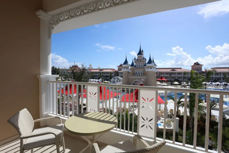 Junior Suite Deluxe Castle View balcony at Bahia Principe Explore Legend overlooking pools and castle towers.