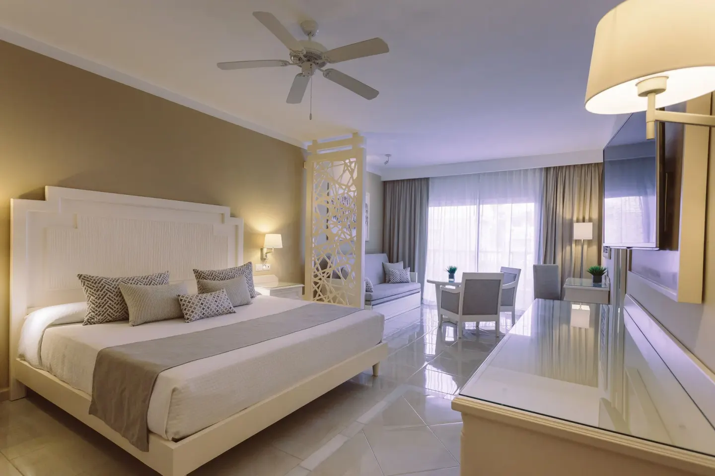 Junior Suite Deluxe king bed with sofa and desk at Bahia Principe Explore Legend.