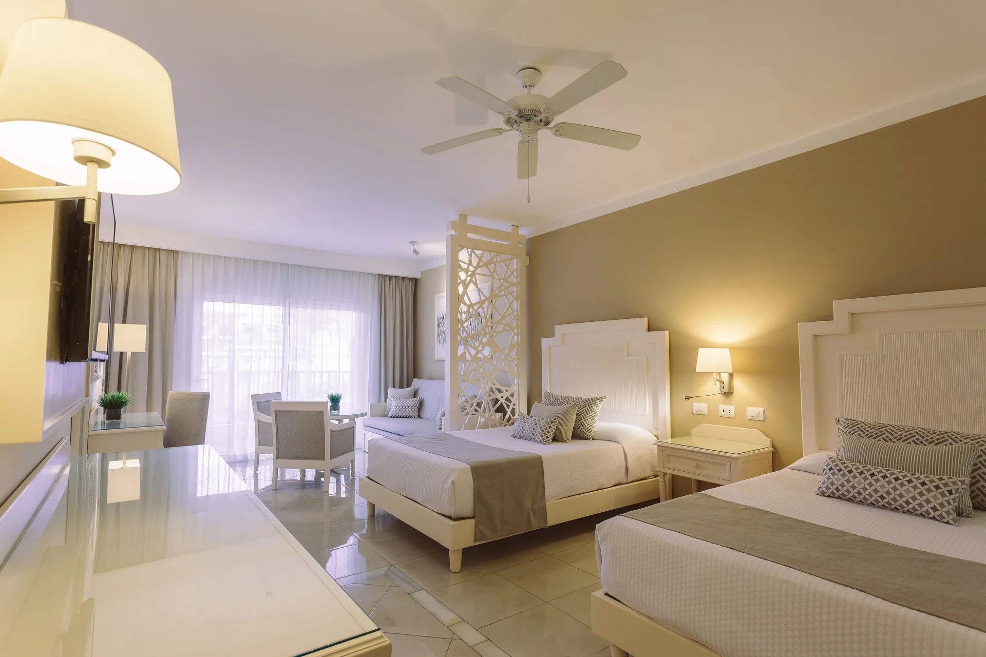 Junior Suite Deluxe with two beds and sitting area at Bahia Principe Explore Legend.