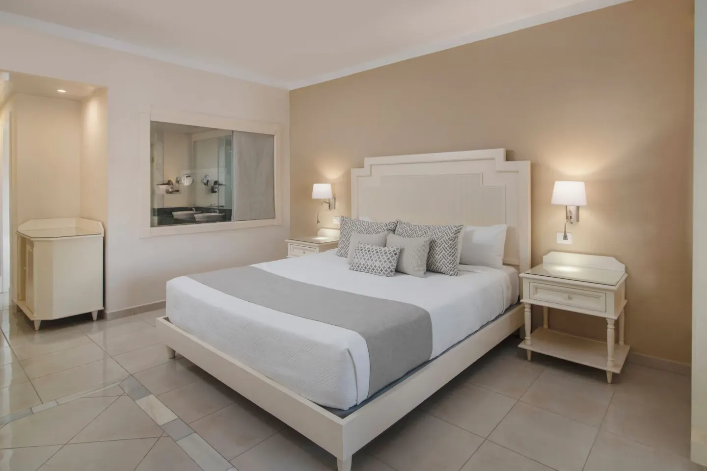Junior Suite king bed with bedside lamps at Bahia Principe Explore Legend.