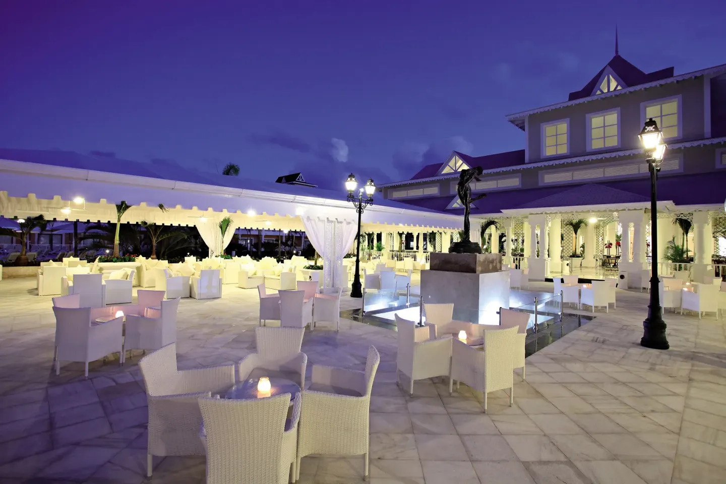 Evening terrace seating and lit fountains at Bahia Principe Grand Aquamarine.