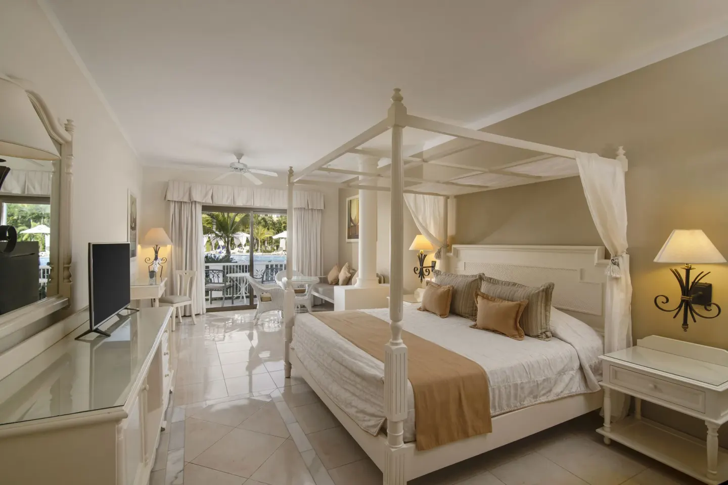 Guest room with a white four-poster king bed at Bahia Principe Grand Aquamarine.
