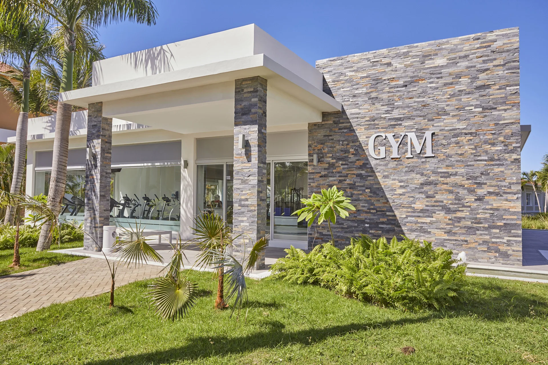 Stone-front gym exterior with a large GYM sign at Bahia Principe Grand Aquamarine.