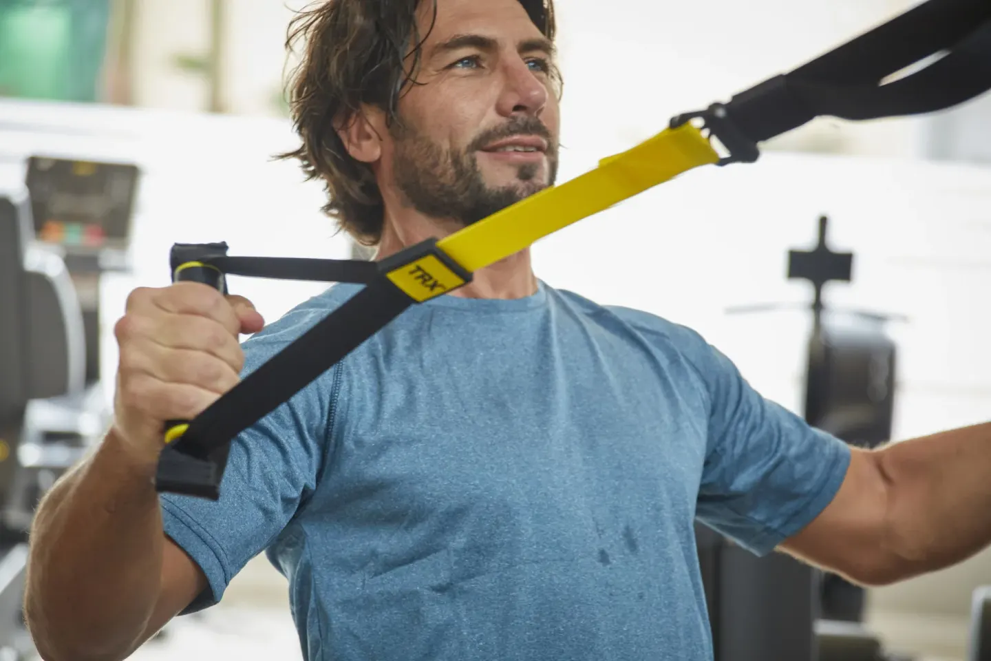 A guest uses suspension straps in the gym at Bahia Principe Grand Aquamarine.