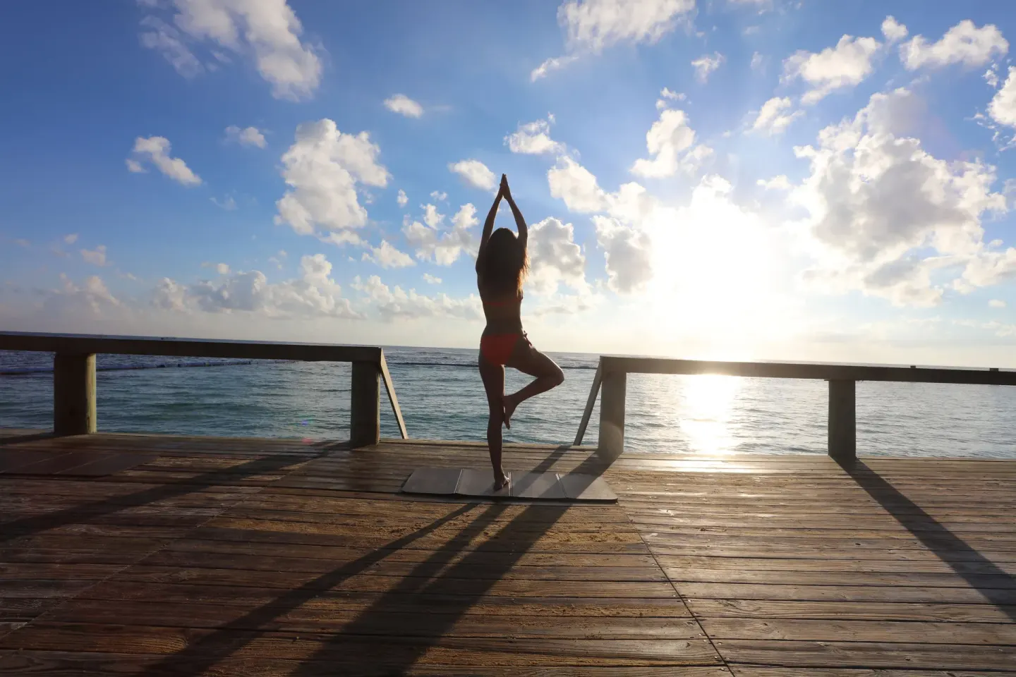 Sunrise yoga on an oceanfront deck at Bahia Principe Grand Aquamarine.