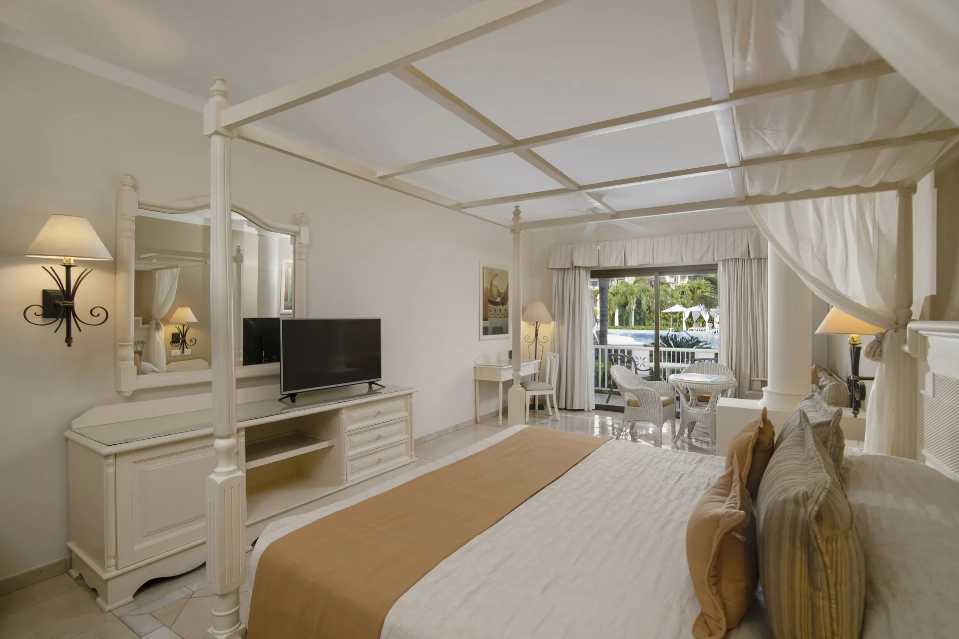 Junior Suite superior room with canopy bed and balcony at Bahia Principe Grand Aquamarine.
