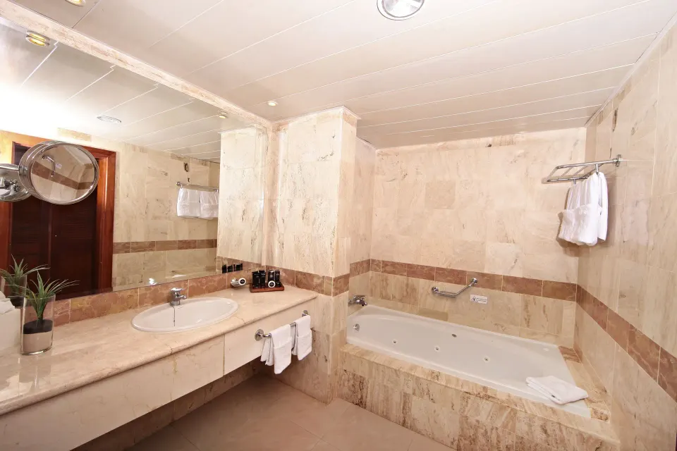 Junior Suite bathroom with tub and vanity at Bahia Principe Grand Aquamarine.