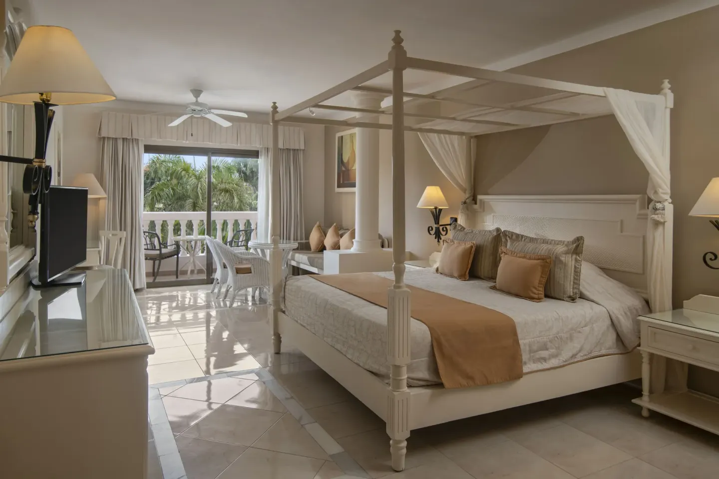 Junior Suite canopy bed with balcony and palm view at Bahia Principe Grand Aquamarine.