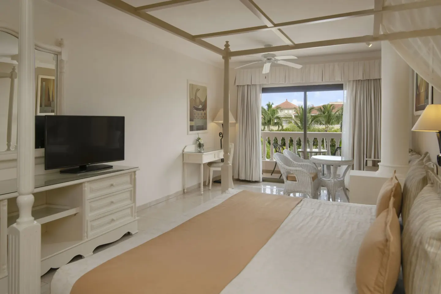 Junior Suite bed, TV, desk and balcony at Bahia Principe Grand Aquamarine.