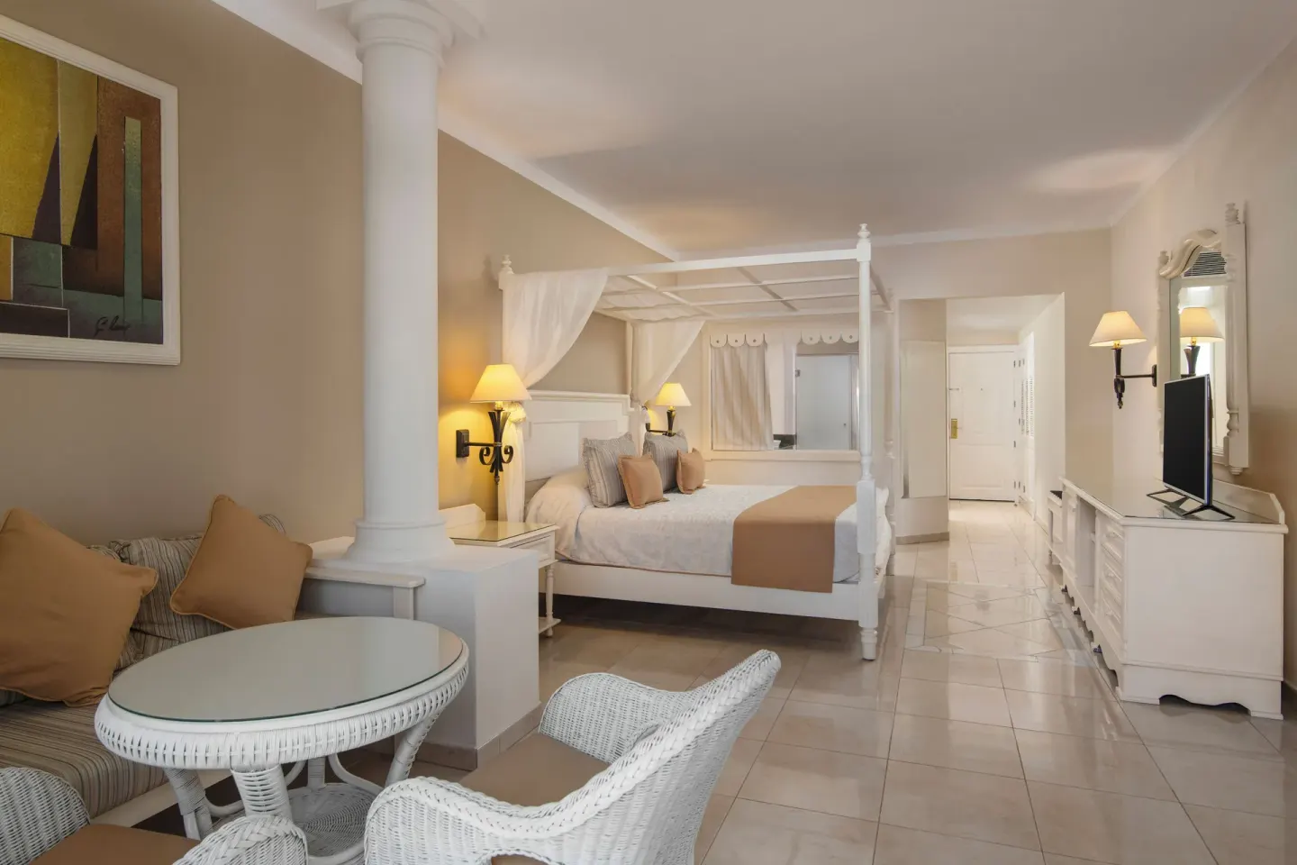 Junior Suite seating area and canopy bed at Bahia Principe Grand Aquamarine.