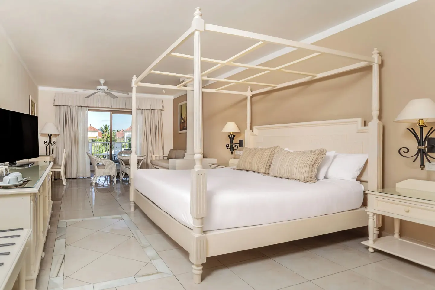 Junior Suite king canopy bed and sitting area at Bahia Principe Grand Aquamarine.