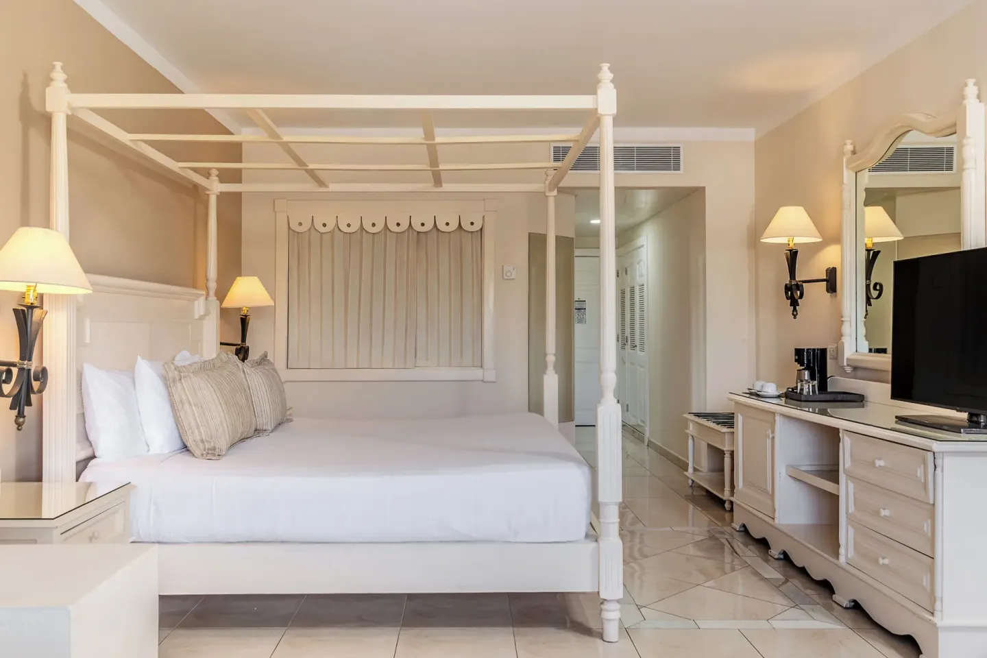 Junior Suite king canopy bed with TV console at Bahia Principe Grand Aquamarine.
