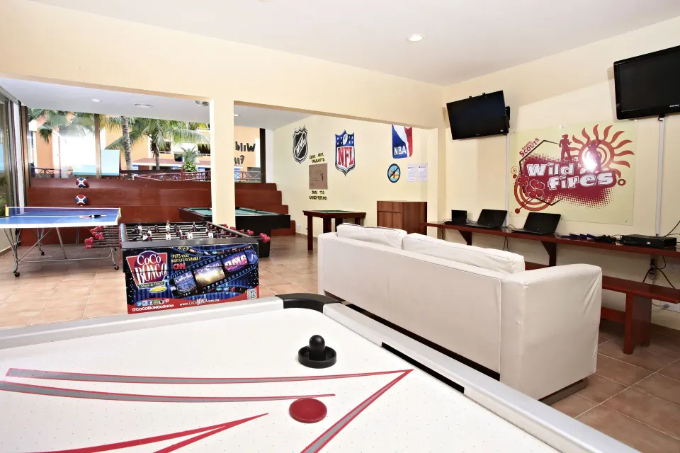 Lounge-style games area with air hockey, foosball and sofas at Bahia Principe Grand Coba
