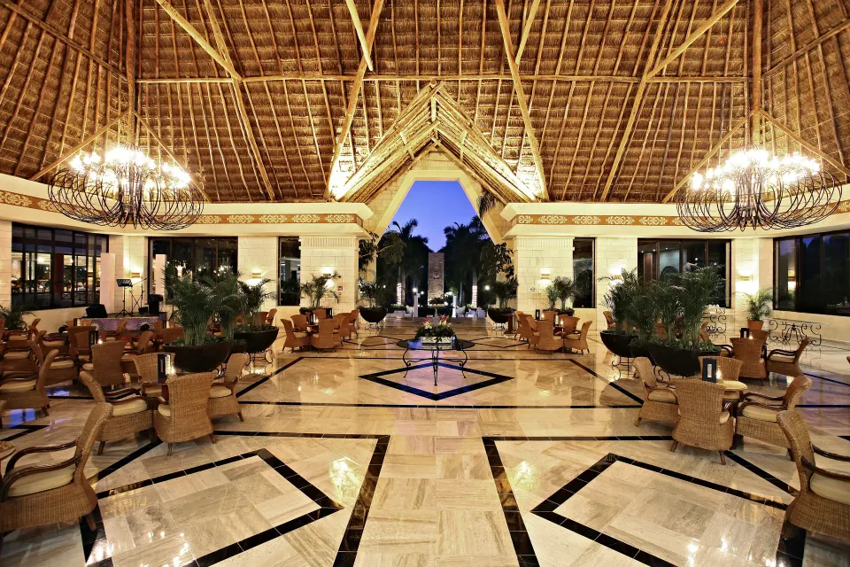 Spacious open-air lobby with high thatched roof at Bahia Principe Grand Coba