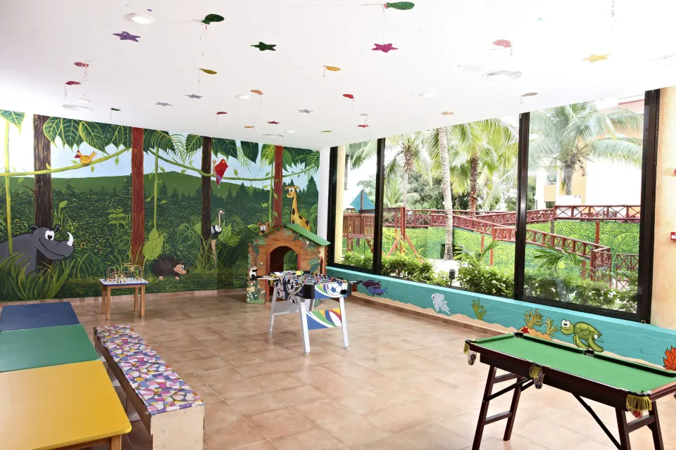 Large indoor kids activity room with murals, foosball and small pool table at Bahia Principe Grand Coba