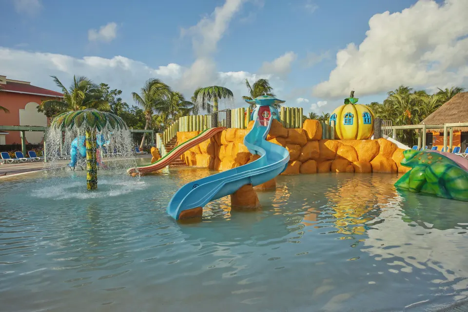 Colorful children's splash pool with slides at Bahia Principe Grand Coba