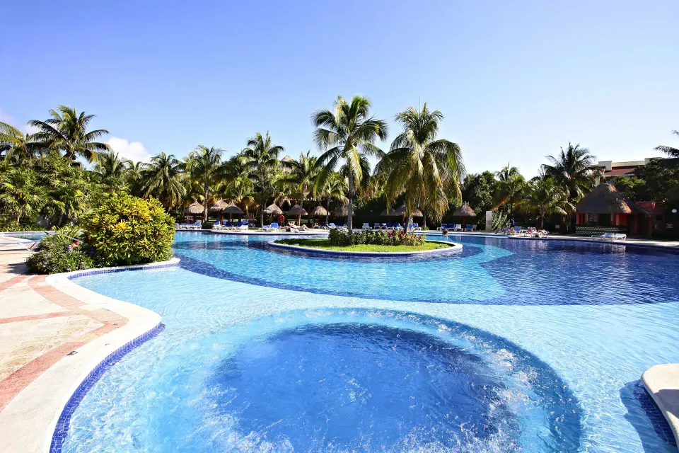 Circular whirlpool inset in a larger blue resort pool at Bahia Principe Grand Coba