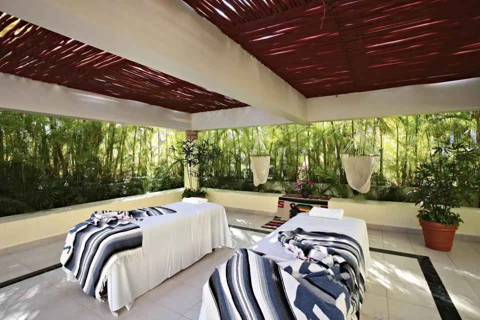 Open-air spa treatment area with two massage tables at Bahia Principe Grand Coba