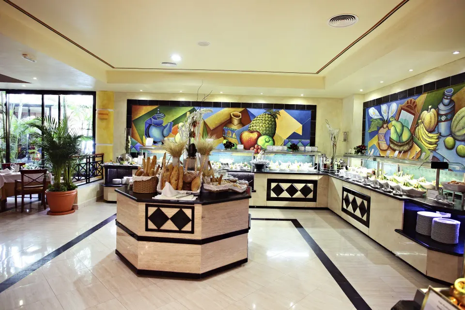 Buffet corner with bread display and fruit mural at Bahia Principe Grand Coba