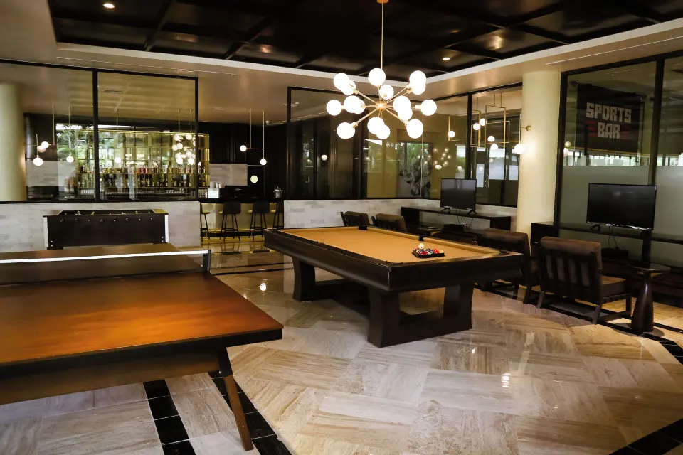 Interior games area with pool table and lounge seating at Bahia Principe Grand Coba