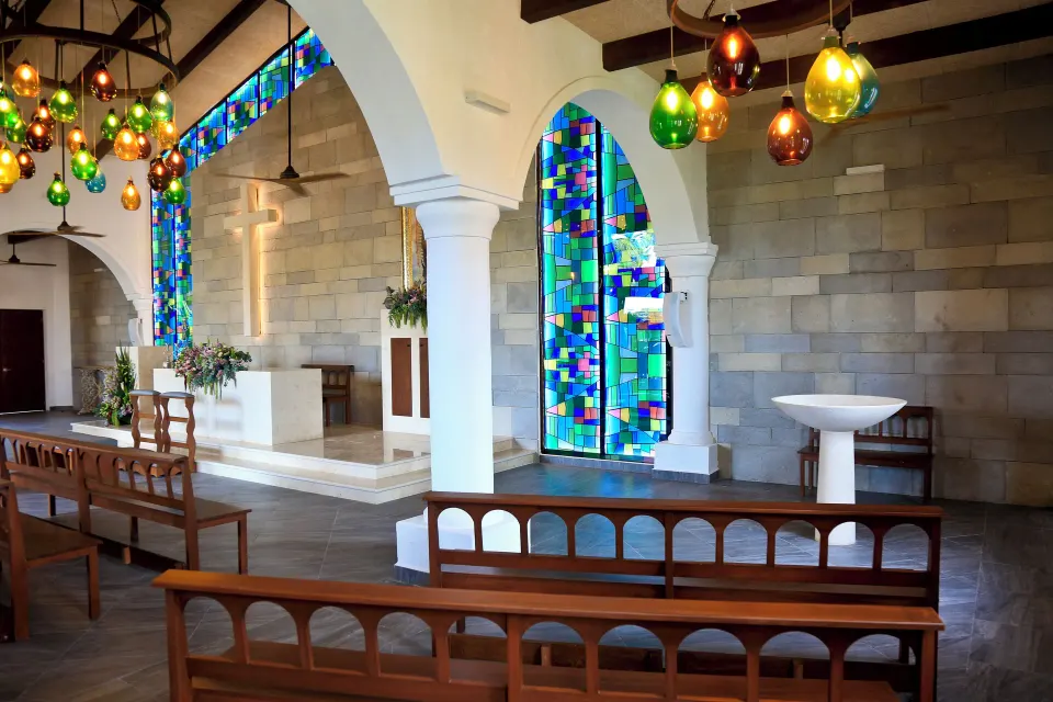 Bright chapel interior with stained glass windows at Bahia Principe Grand Coba