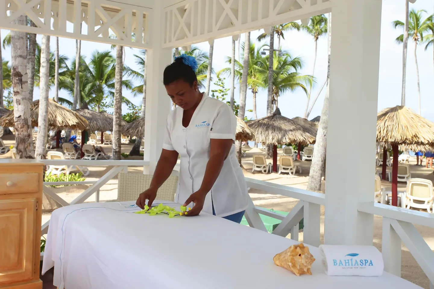 Beachside massage setup at Bahia Principe Grand La Romana with palms and palapas beyond.