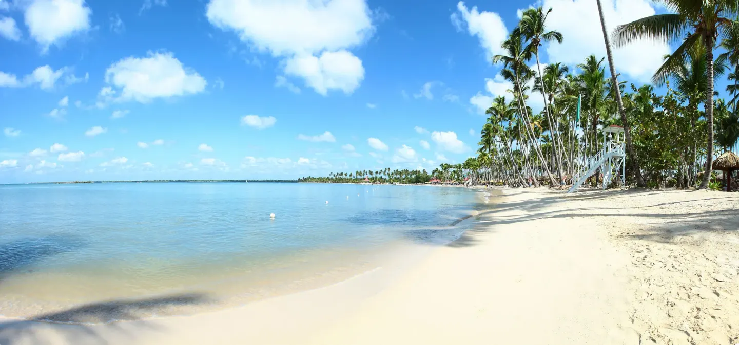 Quiet sandy shoreline with palms and calm sea at Bahia Principe Grand La Romana.