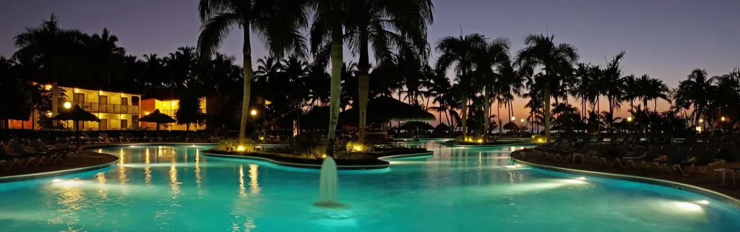 Illuminated pool at dusk at Bahia Principe Grand La Romana.