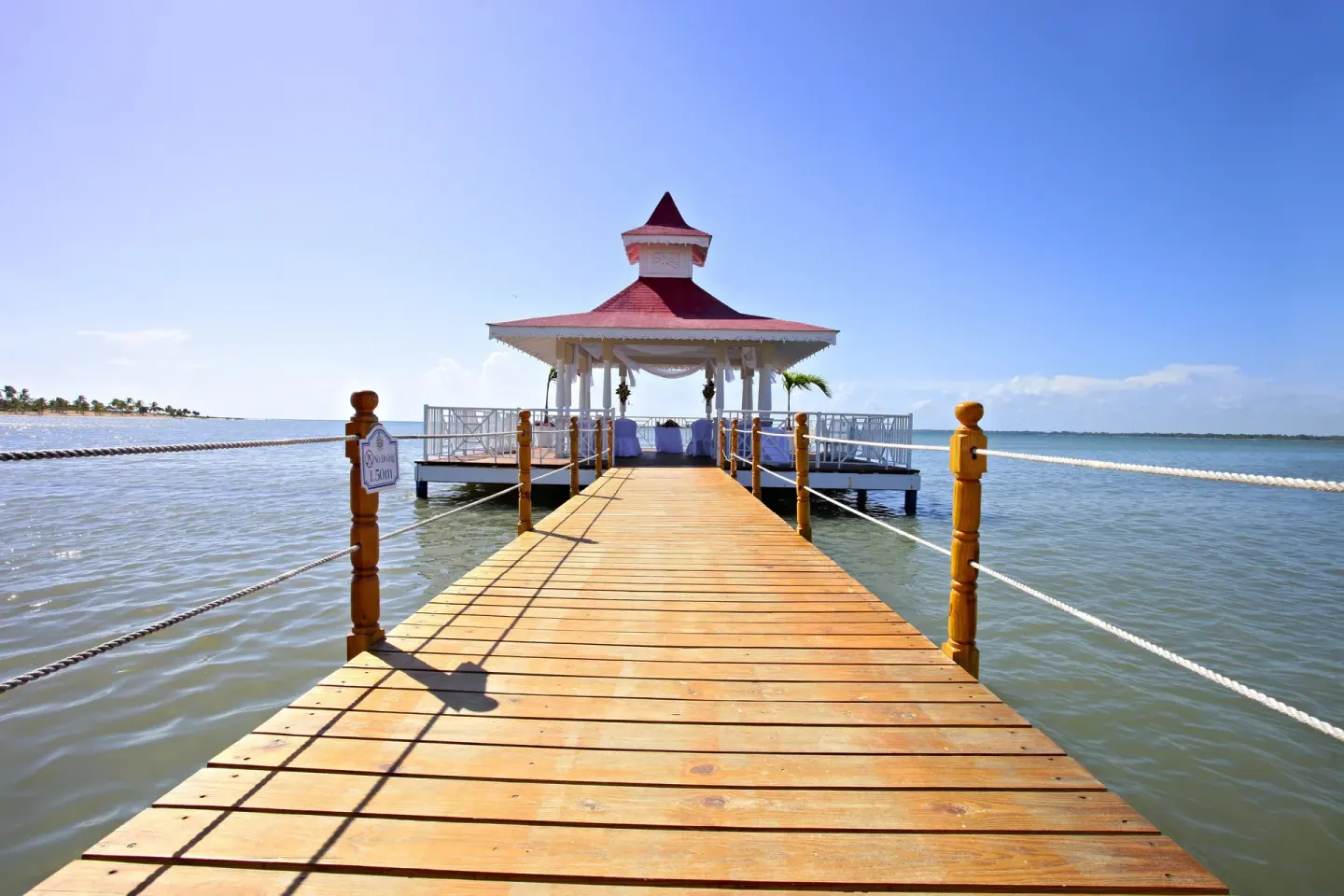 Long wooden pier leading to the overwater gazebo at Bahia Principe Grand La Romana.