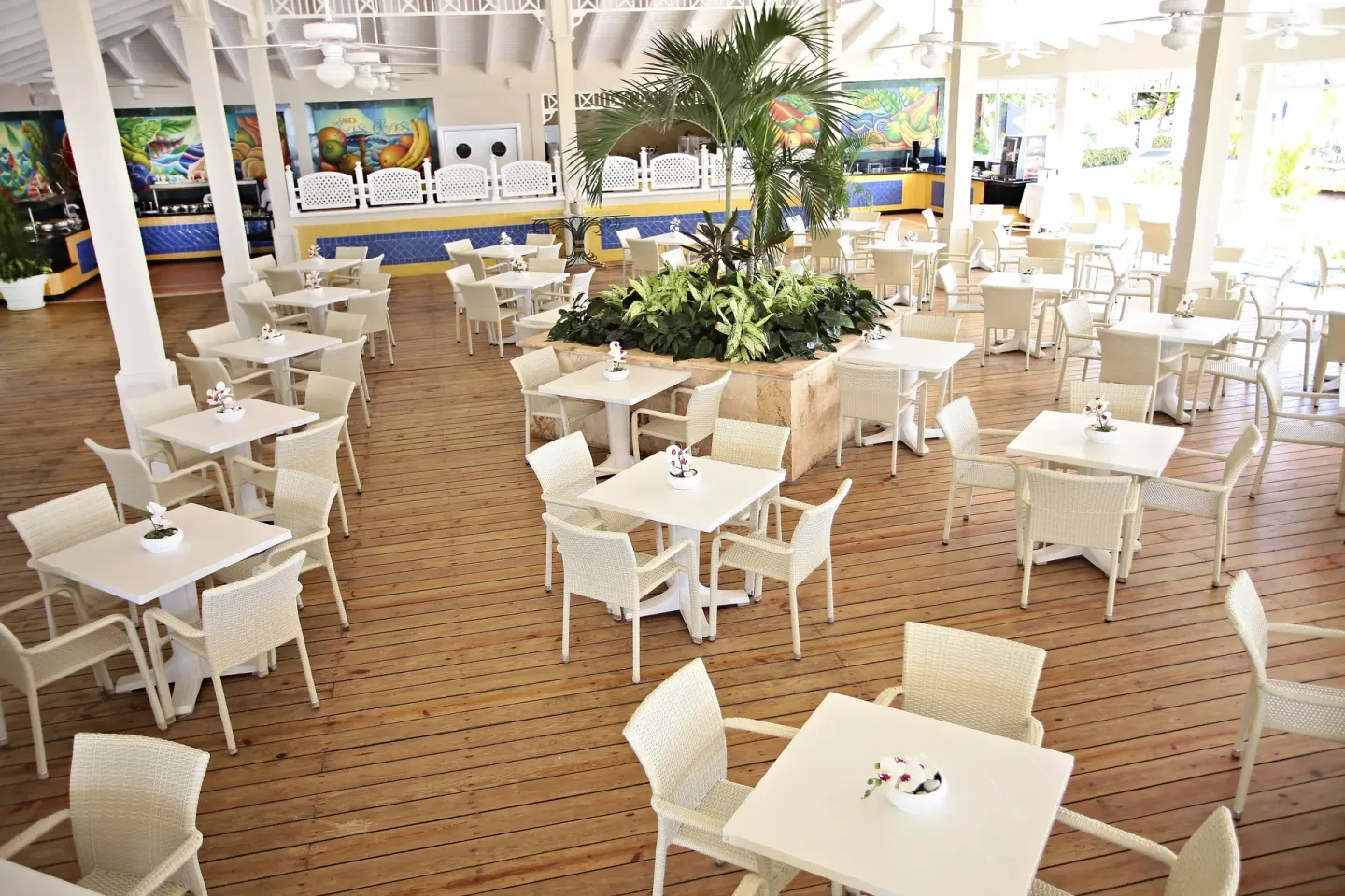 Open-air dining terrace with white tables at Bahia Principe Grand La Romana.
