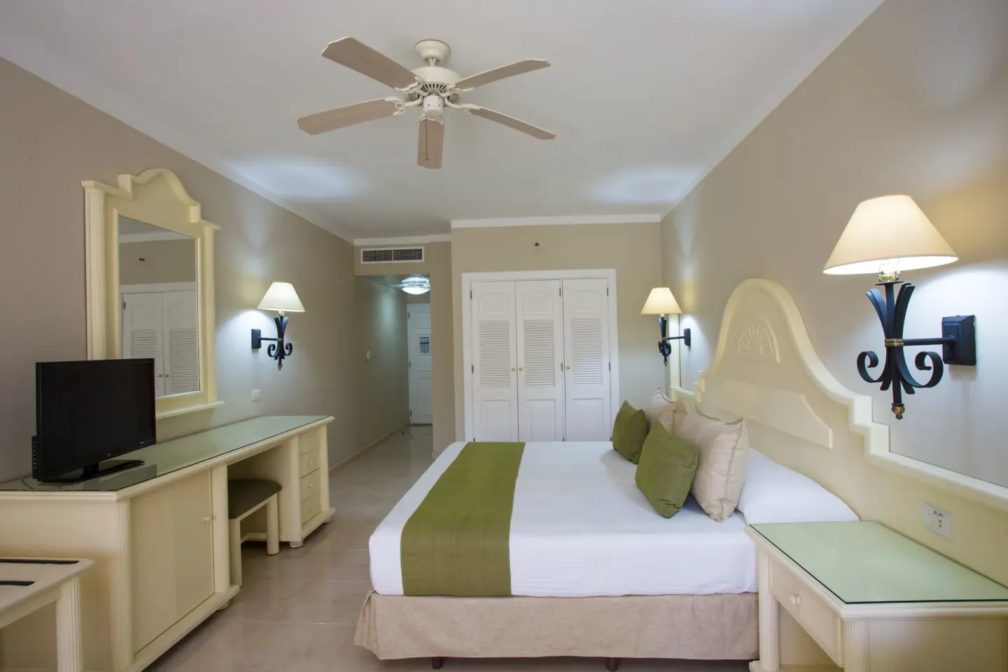 Junior Suite Superior room with king bed, vanity and TV at Bahia Principe Grand La Romana.