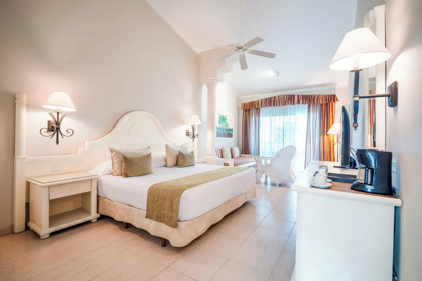 Junior Suite king bed, dresser, TV and coffee maker at Bahia Principe Grand La Romana.