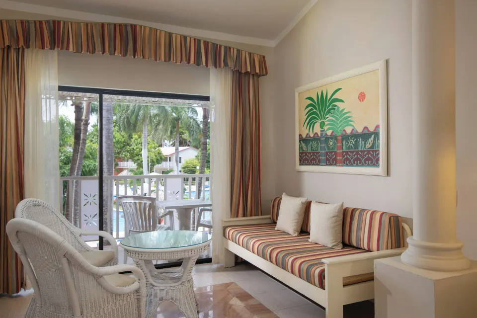 Junior Suite sitting area with daybed and balcony at Bahia Principe Grand La Romana.
