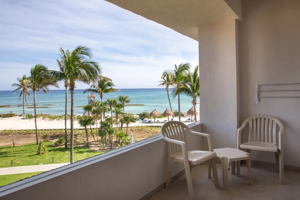 Side-angle balcony view of beach and palm trees at Bahia Principe Grand Tulum