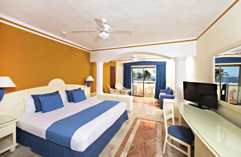 Guest room with king bed and balcony view at Bahia Principe Grand Tulum