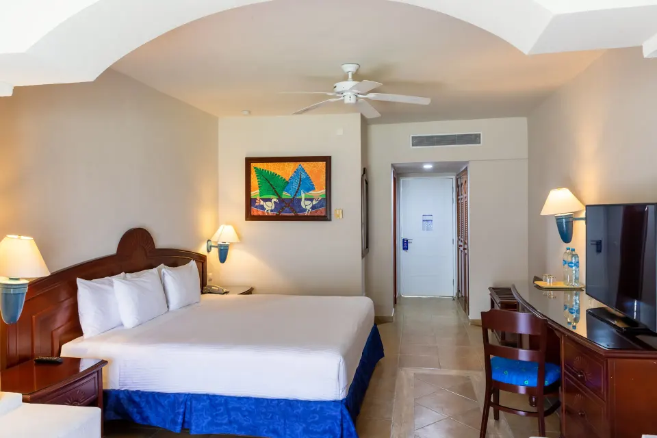 Guest room King bed with desk and TV at Bahia Principe Grand Tulum