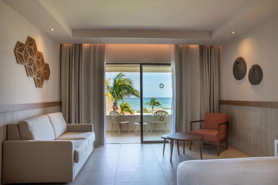 Seating area and balcony with ocean view from a guest room at Bahia Principe Grand Tulum