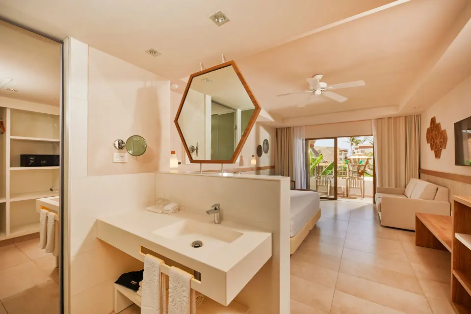 Spacious guest room with vanity, king bed and balcony at Bahia Principe Grand Tulum