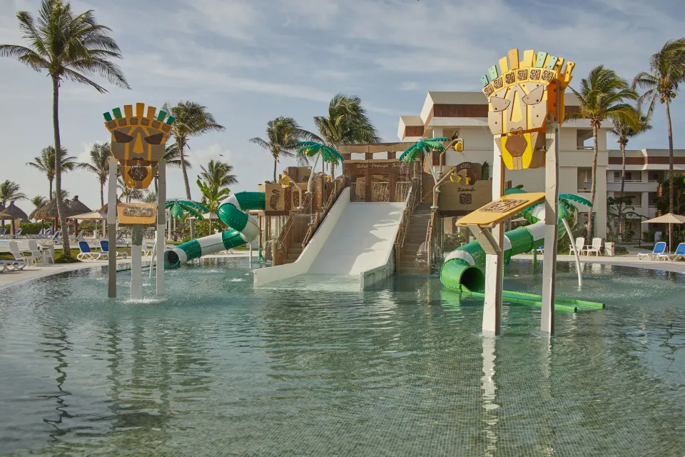 Wide view of the children's multi-slide water play structure at Bahia Principe Grand Tulum