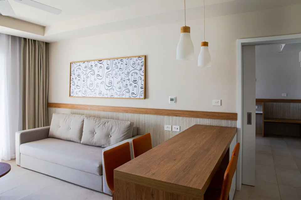 Living area with sofa and dining table in a suite at Bahia Principe Grand Tulum